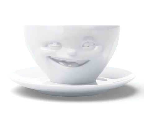 Weiße Tasse mit einem zwinkernden Gesicht und Unterteller.