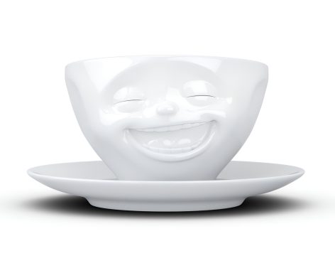 Weiße Tasse mit lachendem Gesicht und passendem Unterteller.
